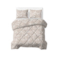 Opgemaakt bed met taupe/zand lazy dekbed met wit bladmotief, ruitvormige stikking en twee bijpassende kussens