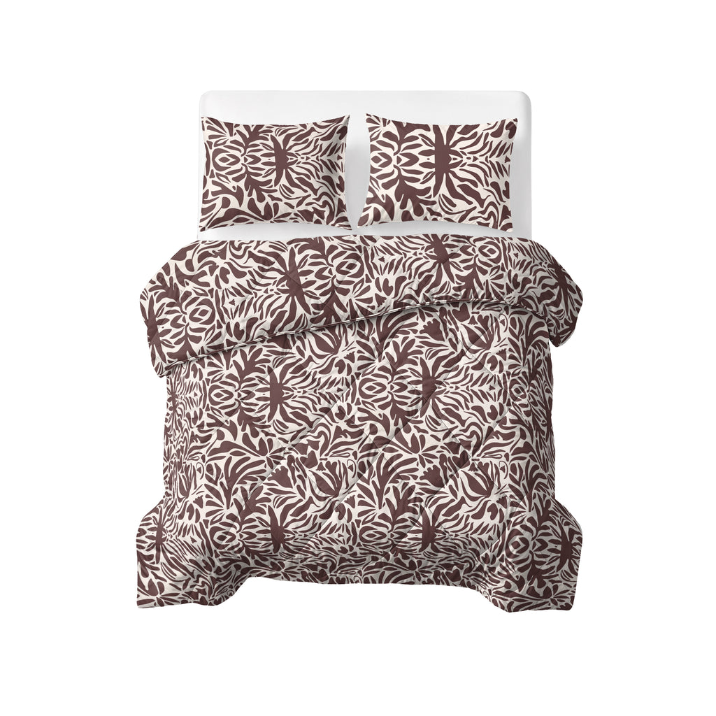 Opgemaakt bed met dekbed en twee kussenslopen met bruin-wit bladpatroon