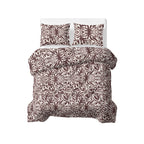 Opgemaakt bed met dekbed en twee kussenslopen met bruin-wit bladpatroon
