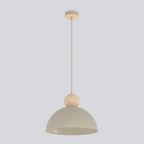 Beige hanglamp met halfronde kap en houten bol aan een dunne stang, tegen een lichtgrijze achtergrond