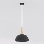 Zwarte koepelvormige hanglamp met houten detail aan een dun zwart snoer en ronde plafondplaat