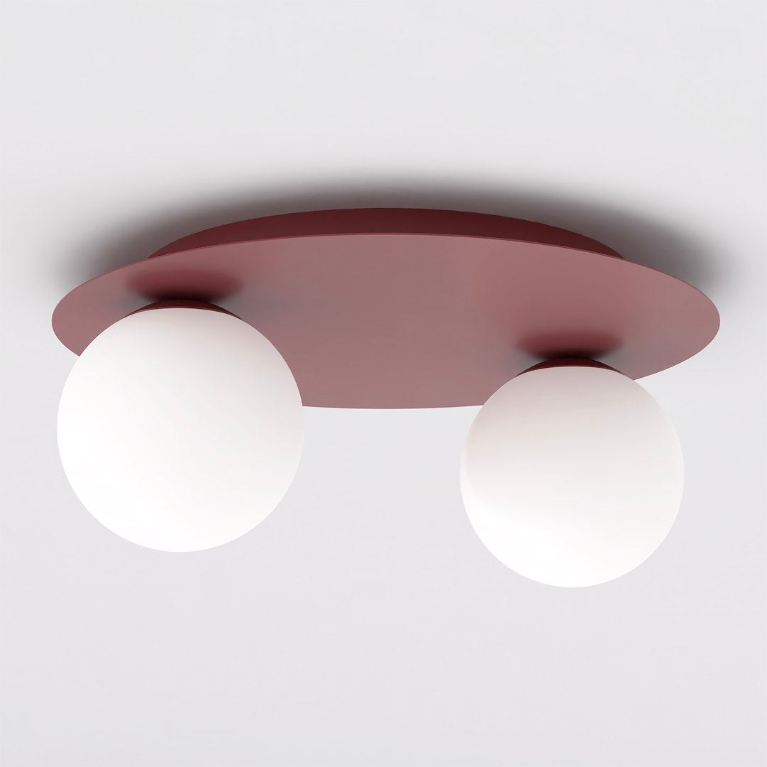 Bordeauxkleurige plafondlamp met ronde plaat en twee witte glazen bollen tegen een wit plafond