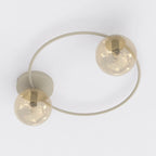 Beige plafondlamp met cirkelvormig frame en twee ronde amberkleurige glazen kappen
