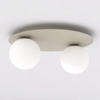 Beige plafondlamp met ronde plaat en twee matte witte glazen bollen tegen een lichte plafondondergrond
