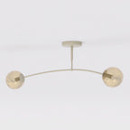 Beige plafondlamp met gebogen frame en twee amberkleurige glazen bollen