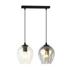 Zwarte hanglamp met twee glazen kappen, één transparant en één grafiet, aan een smalle zwarte balk