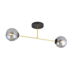 Plafondlamp met twee grijze glazen bollen aan een gouden arm en een zwarte plafondplaat