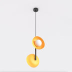 Hanglamp met twee oranje kappen en een witte glazen bol aan een zwarte stang en dunne zwarte ophanging