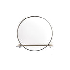 Ronde spiegel met zwart metalen frame en een smalle plank onder in de cirkel, tegen een witte achtergrond