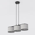 Hanglamp met drie grijze stoffen kappen met zwarte rand aan een zwart frame en twee dunne ophangsnoeren