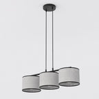 Hanglamp met drie grijze stoffen kappen met zwarte rand aan een zwart frame en twee dunne ophangsnoeren