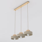 Hanglamp met drie beige stalen kappen met houten details aan een langwerpige houten plafondplaat
