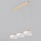 Witte hanglamp met drie ronde kappen met houten rand aan een langwerpige plafondplaat van hout en wit metaal