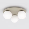 Beige ronde plafondlamp met drie matte witte glazen bollen tegen een wit plafond