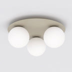 Beige ronde plafondlamp met drie matte witte glazen bollen tegen een wit plafond