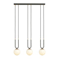 Zwarte hanglamp met drie ronde witte glazen kappen en gouden details aan een rechthoekige plafondplaat