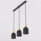 Zwarte hanglamp met drie capsulevormige kappen en houten accenten aan een langwerpige zwarte plafondplaat