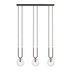 Zwarte hanglamp met drie transparante glazen bollen en gouden details aan een langwerpige plafondkap