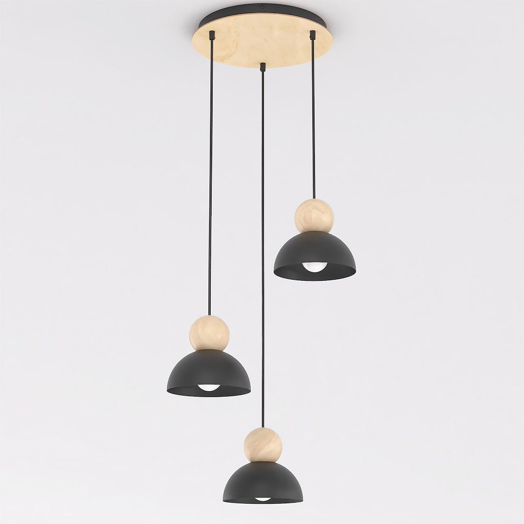 Hanglamp met drie zwarte stalen kappen en houten bollen aan een ronde houten plafondplaat