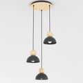 Hanglamp met drie zwarte stalen kappen en houten bollen aan een ronde houten plafondplaat