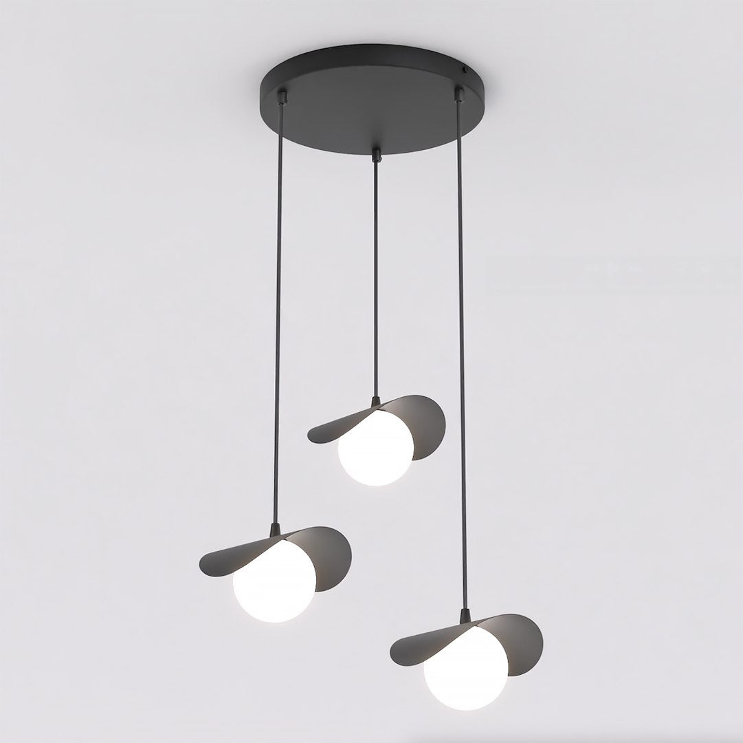 Zwarte hanglamp met drie pendels op verschillende hoogtes, bloembladachtige kapjes en witte bolletjes aan rond plafondrozet