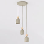 Hanglamp met drie beige capsulevormige kappen en houten accenten aan een ronde beige plafondplaat