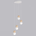 Hanglamp met vier witte bolkappen en houten bollen aan witte snoeren onder een ronde witte plafondplaat