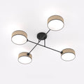 Vierarmige plafondlamp met zwart frame en vier cilindervormige kappen met rotanpatroon