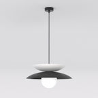 Hanglamp met witte en zwarte gelaagde schijven en een matte glazen bol, opgehangen aan een dunne zwarte stang