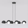 Zwarte lineaire hanglamp met zes halfbolvormige kappen en witte bollen aan een balk, opgehangen aan twee dunne kabels