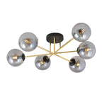 Plafondlamp met zes grafietkleurige glazen bollen aan gouden armen en een zwarte ronde plafondplaat