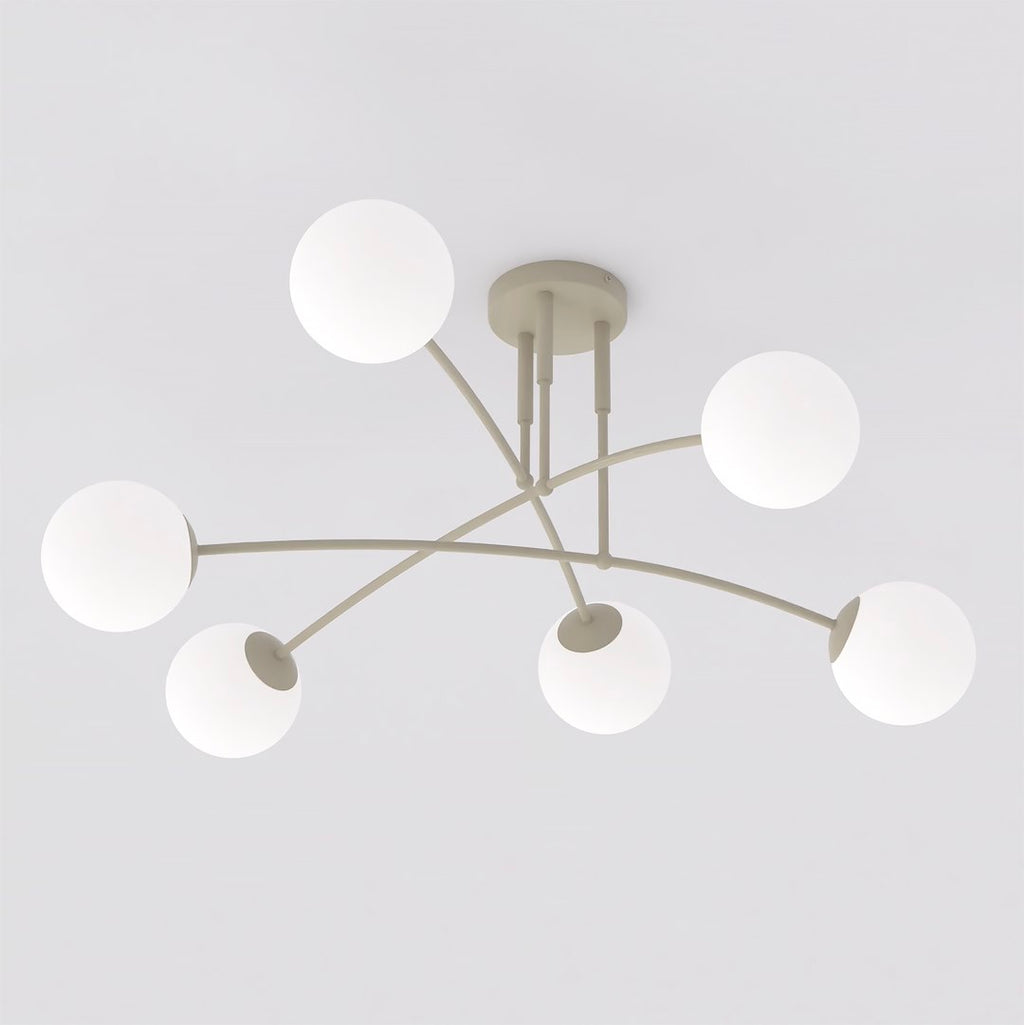 Beige plafondlamp met zes gebogen armen en witte glazen bolkappen tegen een lichte achtergrond