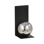 Zwarte wandlamp met hoekige stalen plaat en ronde glazen kap in grafiet met spiegelend effect