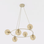 Beige ronde hanglamp met zes amberkleurige glazen bollen aan drie dunne ophangsnoeren