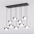 Zwarte clusterhanglamp met negen pendels op verschillende hoogtes, gebogen kappen en witte bollen