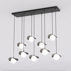 Zwarte clusterhanglamp met negen pendels op verschillende hoogtes, gebogen kappen en witte bollen