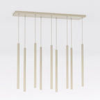 Beige hanglamp met negen dunne cilindrische pendels van verschillende lengte aan een langwerpige plafondplaat