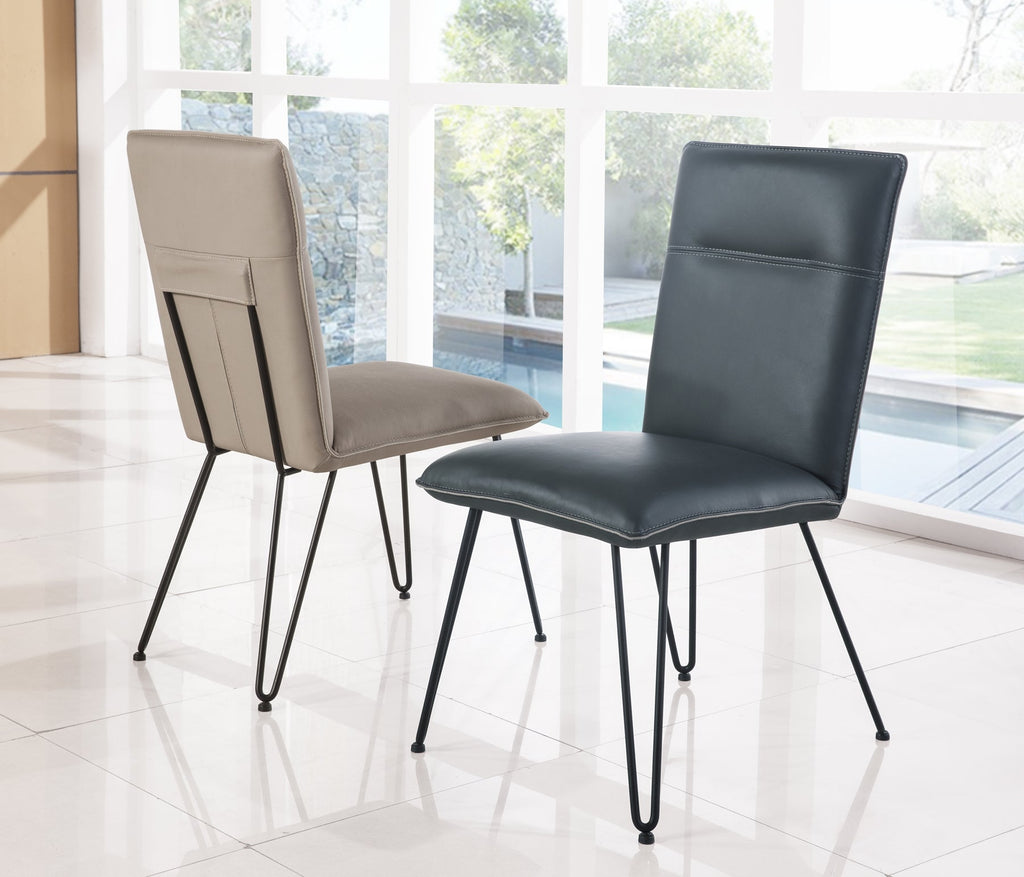 Twee eetkamerstoelen met zwarte hairpin-poten, een taupe en een donkerblauw, in een lichte ruimte met grote ramen