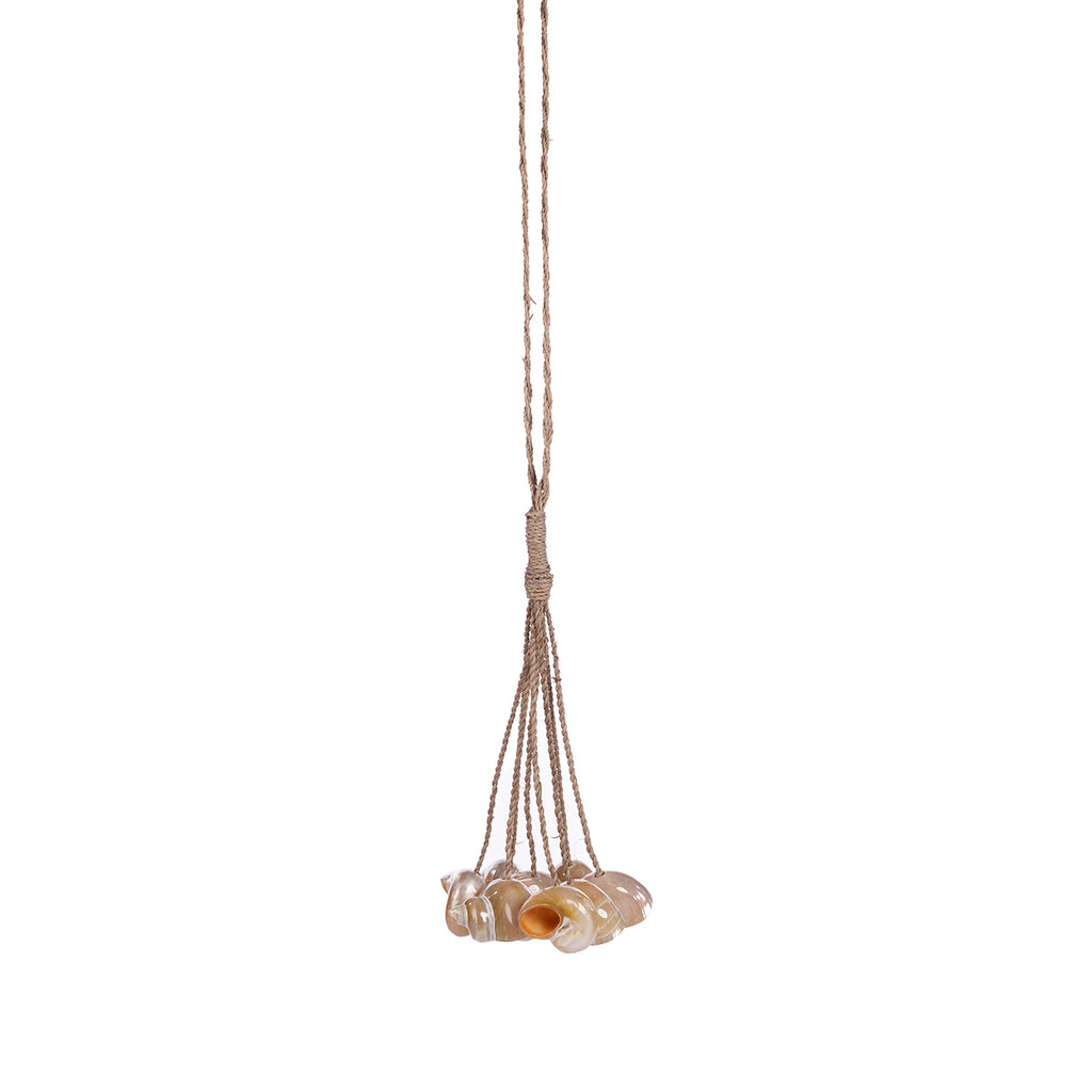Hangende kwast met naturel schelpen aan gevlochten koorden op een witte achtergrond