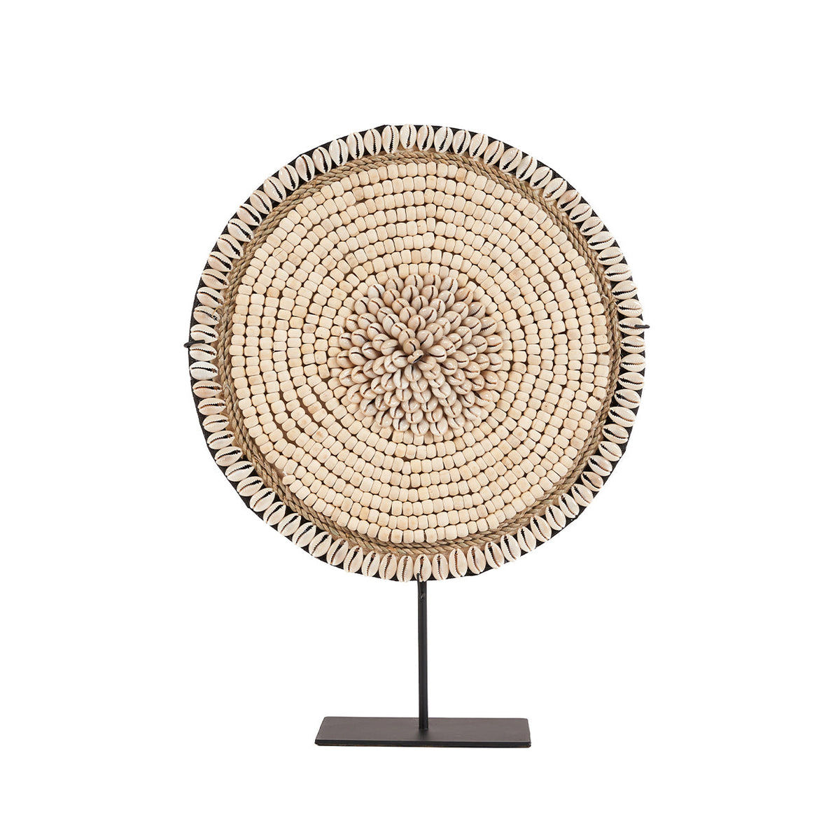 Ronde decoratieschijf van beige kralen en witte schelpen op een zwarte metalen standaard