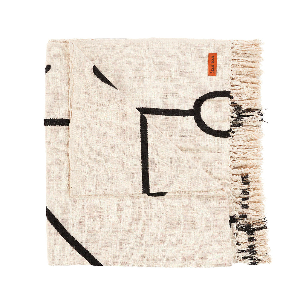 Opgevouwen ecru plaid met zwart Evil Eye-lijnenmotief en franje aan de zijkant