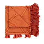 Opgevouwen terracotta plaid van katoen met diagonale banen, lange franjes en kwastjes