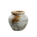 Bolle grijze terracotta vaas met roestoranje tinten en een rand van naturel raffia