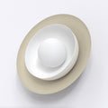 Wandlamp met ovale beige schijf, witte halve kom en matwitte bol, gezien van voren
