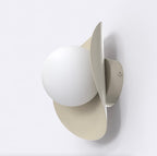 Wandlamp met witte bol en lintvormig scherm van gepoedercoat staal in mokka, aan een lichte wand