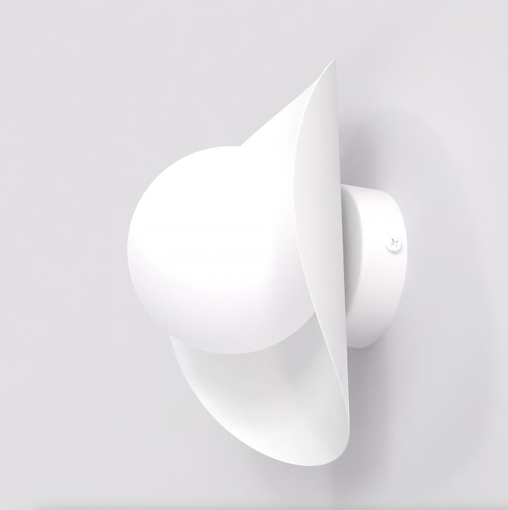 Witte wandlamp met ronde bol en lintvormig scherm aan een lichte wand