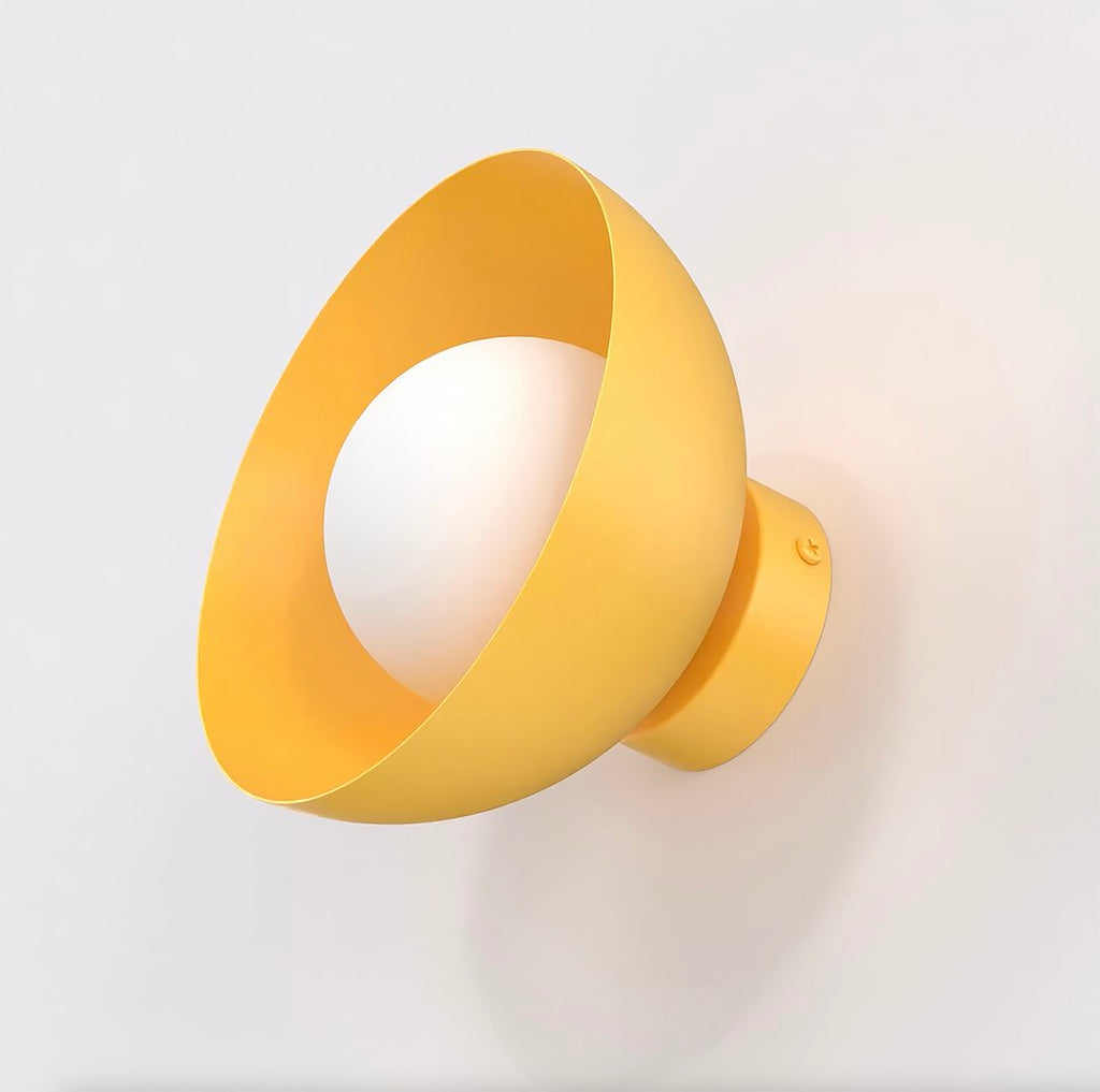 Wandlamp met schuin geplaatste komvorm in oranje en een witte bolvormige kap, bevestigd aan een lichte muur