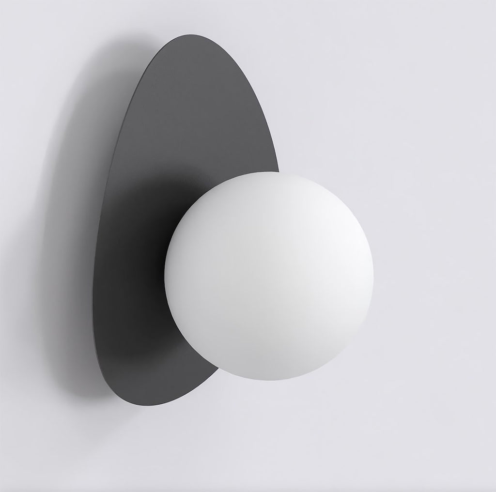 Zwarte wandlamp met kiezelvormige stalen achterplaat en ronde witte bol als kap