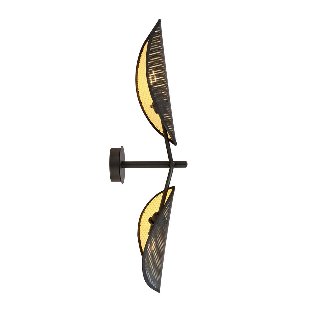 Zwarte wandlamp met twee bladvormige, geperforeerde lampenkappen met gouden binnenzijde aan een dunne wandarm