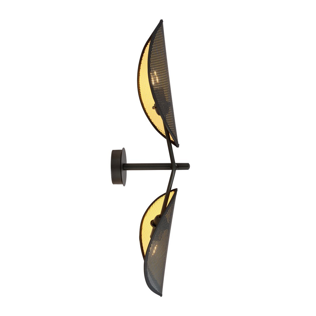 Zwarte wandlamp met twee bladvormige, geperforeerde lampenkappen met gouden binnenzijde aan een dunne wandarm
